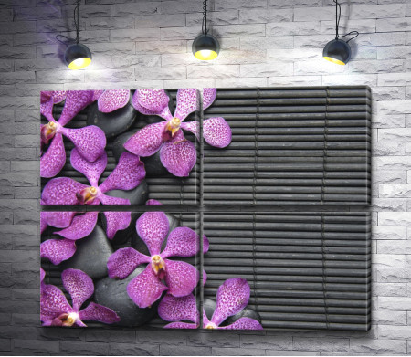 Лиловые орхидеи на камнях и бамбуковом коврике