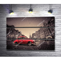 Красный ретро автомобиль на булыжной мостовой