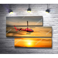 Красный вертолет в небе во время заката 