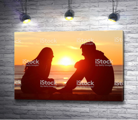 Парень и девушка беседуют на фоне заката