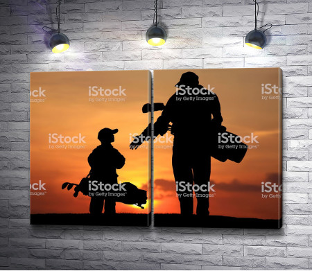 Папа и сын перед игрой в гольф на закате 