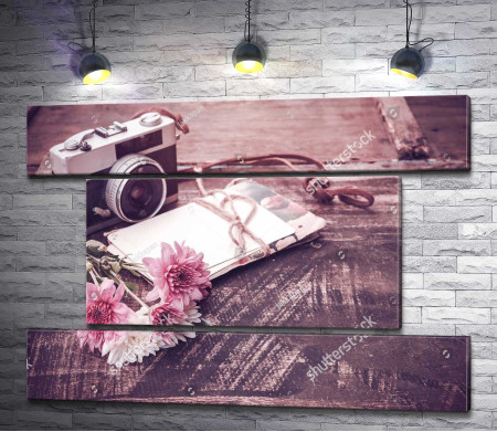 Винтажный фотоаппарат с букетом цветов на деревянном столе