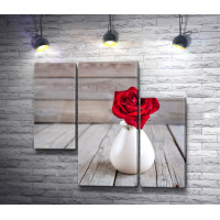 Красная роза в белой вазе на деревянном столе 