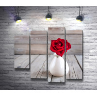 Красная роза в белой вазе на деревянном столе 