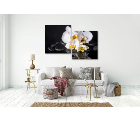 Белая орхидея и камни спа на черном фоне