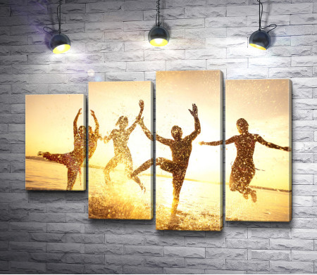 Люди танцуют на берегу моря во время заката