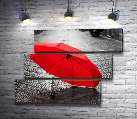 Красный зонт лежит на асфальте 