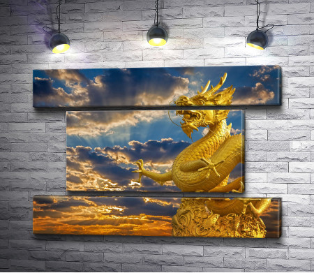 Статуя золотого дракона на фоне заката 