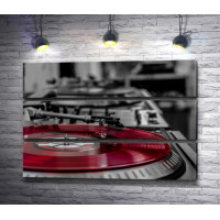 Красная виниловая пластинка в проигрывателе, черно-белое фото с акцентом 
