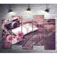 Винтажный фотоаппарат с букетом цветов на деревянном столе
